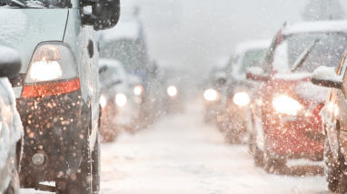 Front view of traffic with cars in a snowy road