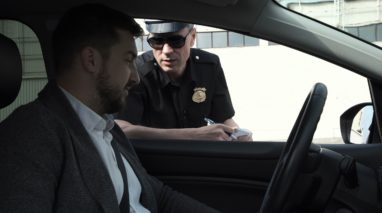 Man inside his car with a police officer in his window