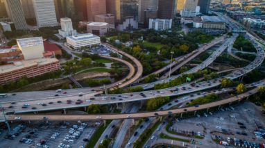 Aerial view of a highway with a bridge and lots of cars