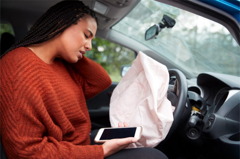 Woman inside her car with activated air bag aching