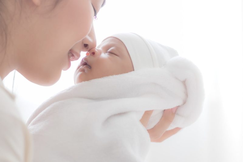 Mom holding newborn baby close