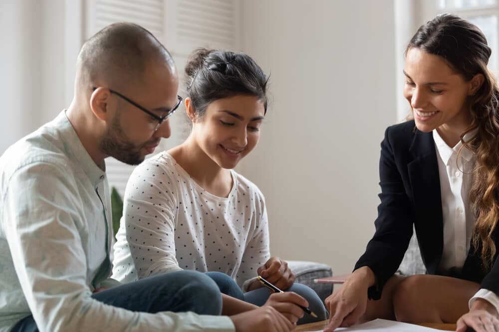 independent insurance agent with couple signing a policy