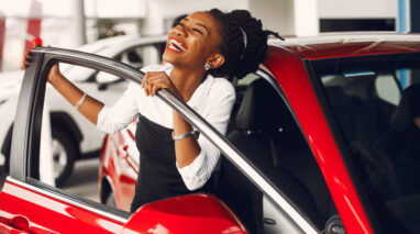 african american woman smiling by new car