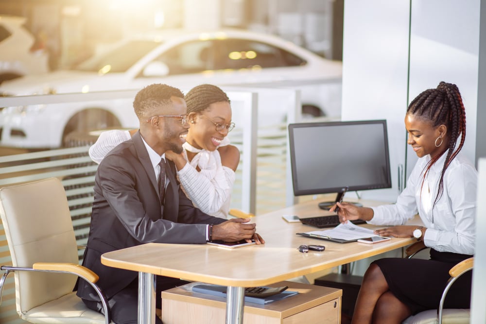 young african american couple at car dealership getting a lease