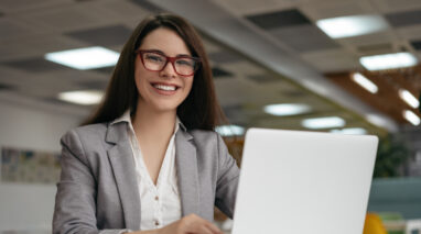 insurance agent smiling next to laptop