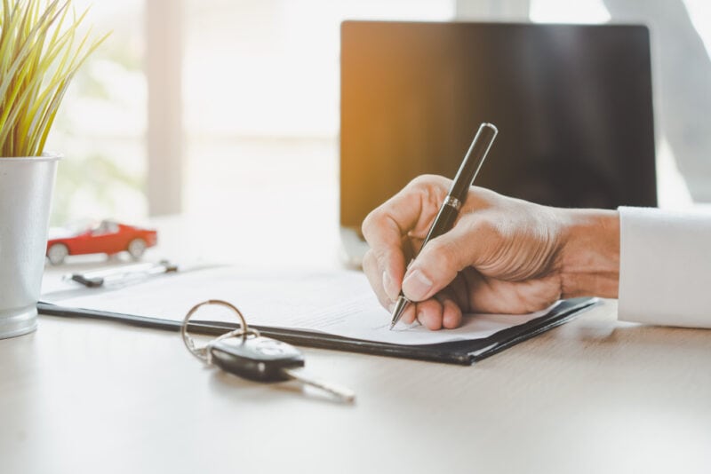 person signing auto lease document