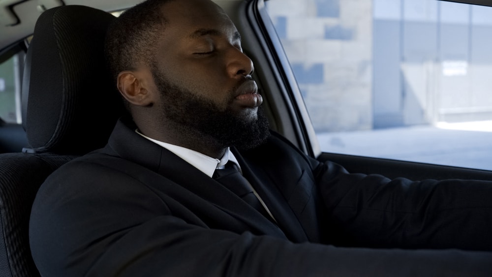 Man meditates behind the wheel to avoid stress