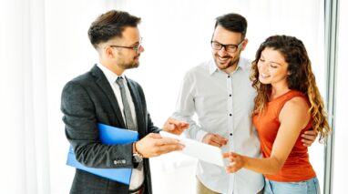 Insurance agent showing contract to young couple