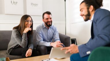 Young male insurance agent with smiling couple