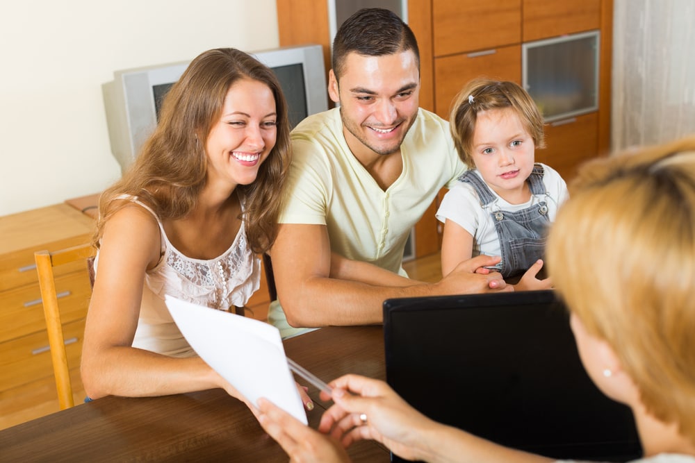 Young couple with child listen to insurance agent