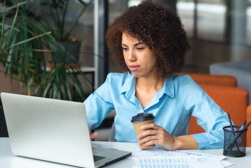 Young African American woman looks at laptop on desk