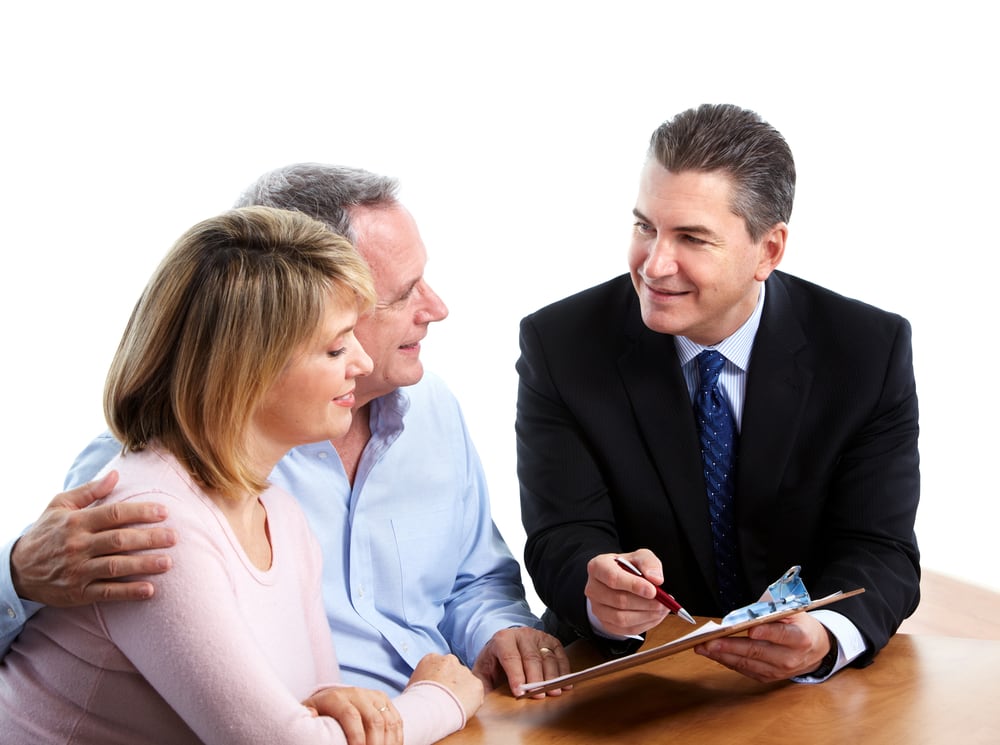 Insurance agent goes over contract with smiling senior couple