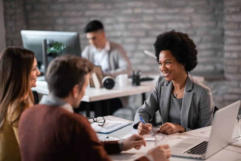 Client asks questions of insurance agent sitting across the table from each other